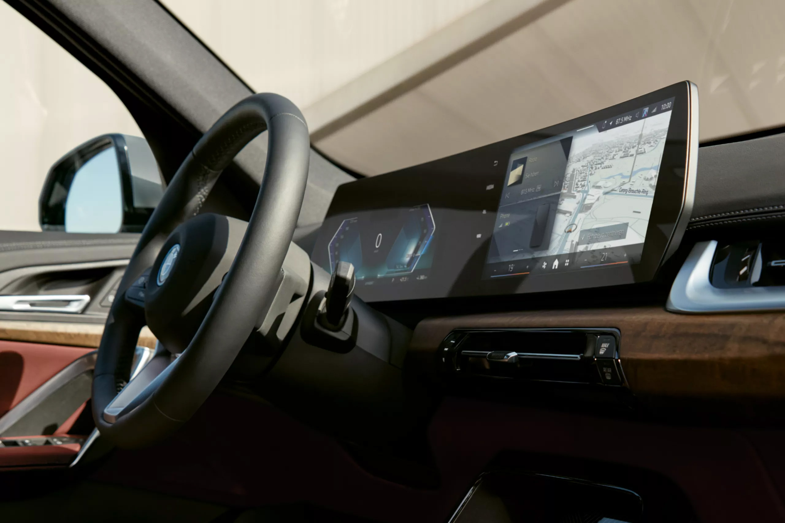 Auf diesem Bild ist der moderne Innenraum eines Autos mit einem Lenkrad, einem breiten, gebogenen digitalen Display, das Navigations- und Fahrzeuginformationen anzeigt, und edlen Holzapplikationen am Armaturenbrett zu sehen.